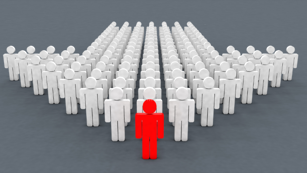 Red figure standing confidently in front of a group of white figures, symbolizing leadership, action, and driving change through advocacy.